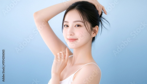 清潔感のある若い女性のビューティーポートレート、髪をまとめてうなじと腕を見せるスキンケア・ボディケア広告向けの透明感イメージ