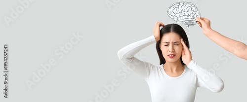 Εκτύπωση καμβά Young Asian woman suffering from headache and hand holding paper brain on light