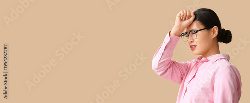Young Asian woman suffering from headache on beige background. Brain Injury A...