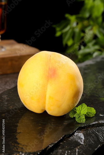 Fresh Yellow Peach Cut in Half with Mint on Dark Stone Surface - Healthy Organic Fruit Still Life Photography