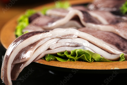 Fresh Raw Squid Tentacles with Lettuce on Wooden Board Studio Food Photography