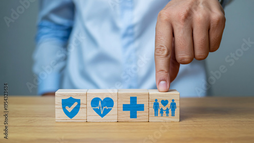 A person placing a block with a family icon on a table with health and protection symbols.