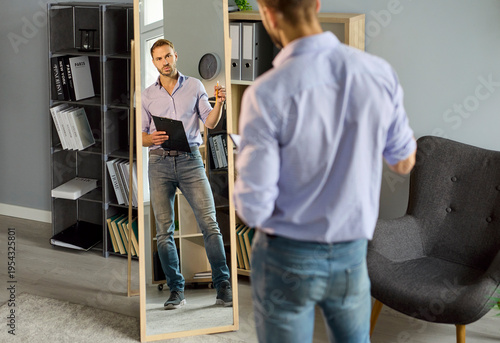 Foto Man job seeker rehearses interview speech before office mirror
