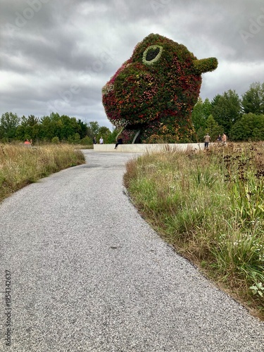 Curved pathway leading to large colorful floral sculpture in park