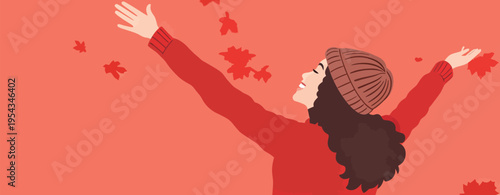 Woman enjoys falling leaves in autumn setting while wearing a warm hat and red sweater and smiles with arms open wide