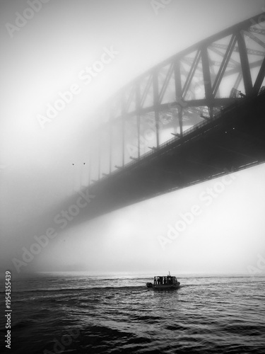 Boat Passing Beneath Sydney Harbour Bridge in Dense Fog