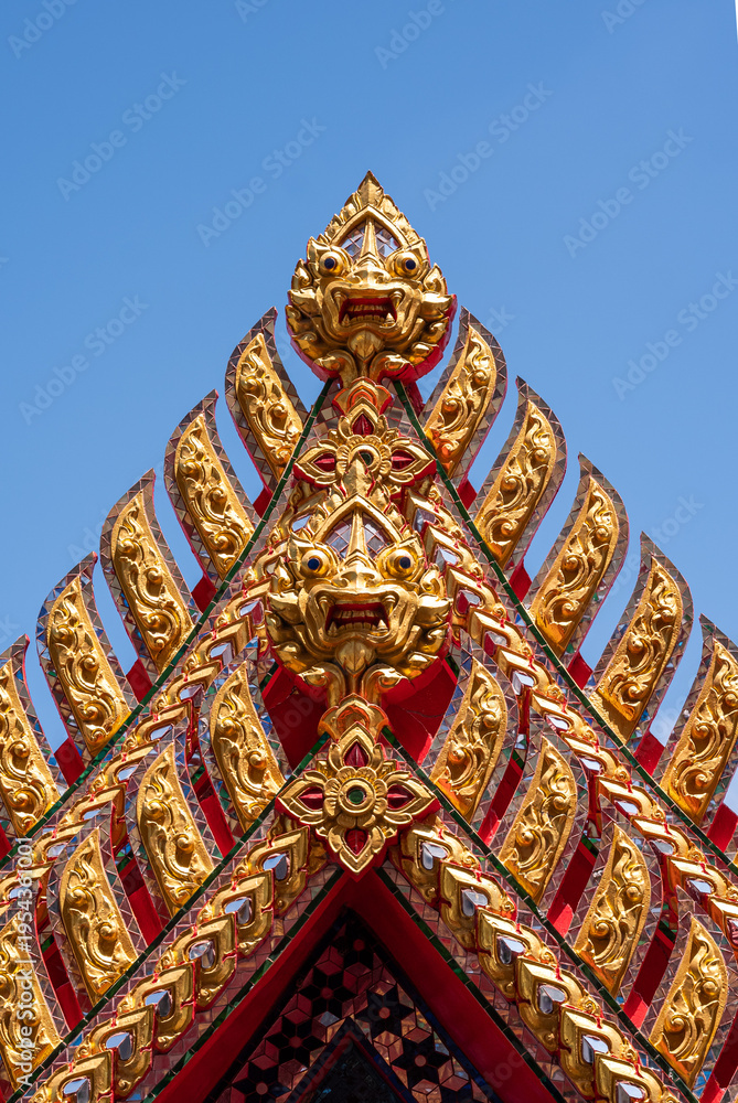 Fototapeta premium Traditional Thai Architectural Decorative Detail with Gilded Carvings and Glass Mosaic.