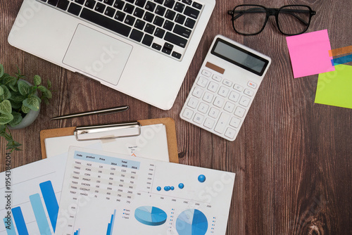 Office desk with financial documents and laptop