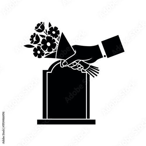 Hand placing flowers on a tombstone.