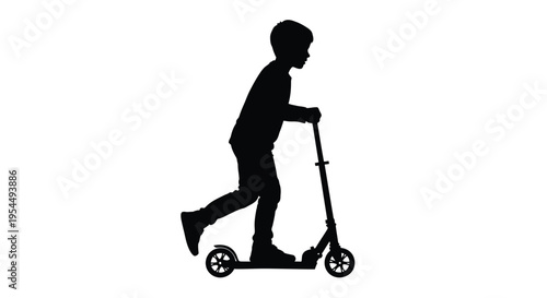 A young boy rides a scooter in a dark striking silhouette