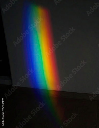Light refracting into spectrum against a wall, creating vibrant color display