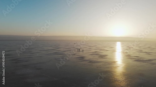 fishermen on the frozen lake, morning light