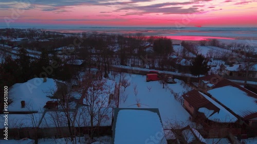 Frozen Lake Sunset Over Snow Covered Village in Romania