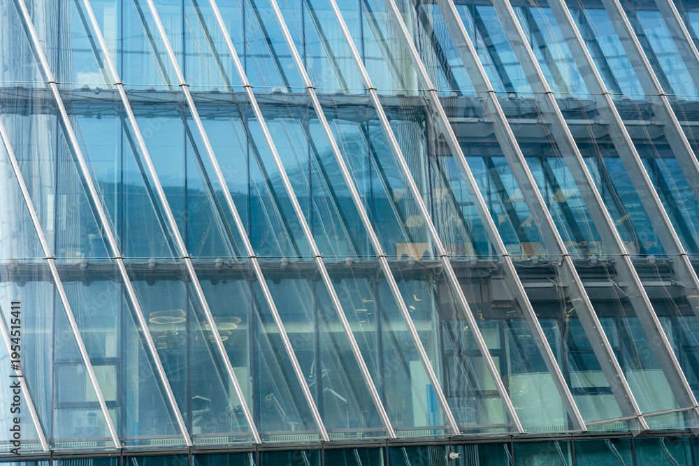 Obraz premium A sleek, modern skyscraper with a grid of reflective glass windows rises sharply into the sky. The concept of backgrounds for business ideas