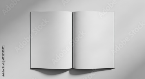 A grayscale image of an open book with blank white pages casting a subtle shadow on a light background