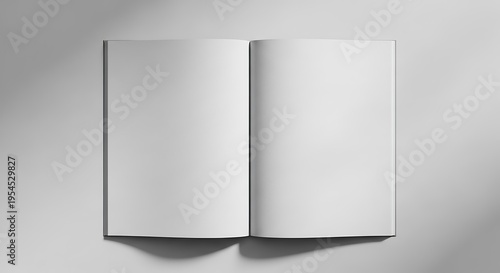 A grayscale image of an open book with blank white pages on a gray background with shadows
