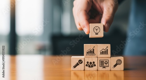 Hand placing wooden block with lightbulb on business strategy stack aspect ratio 16 9