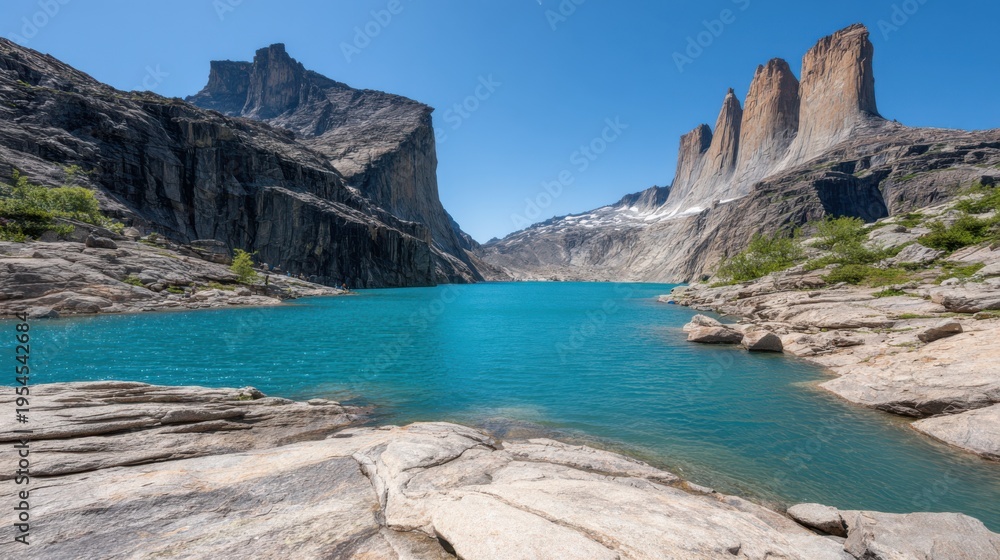 Obraz premium Serene Blue Lake Surrounded by Majestic Mountains Under Clear Sky in Remote Wilderness Landscape