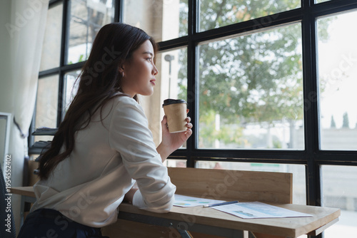 Foto Young woman drinking coffee contemplating future plans