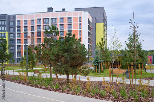 modern residential buildings with green spaces in urban setting. colorful facades contrast with nature, highlighting sustainable architecture and city living, encouraging outdoor activities.