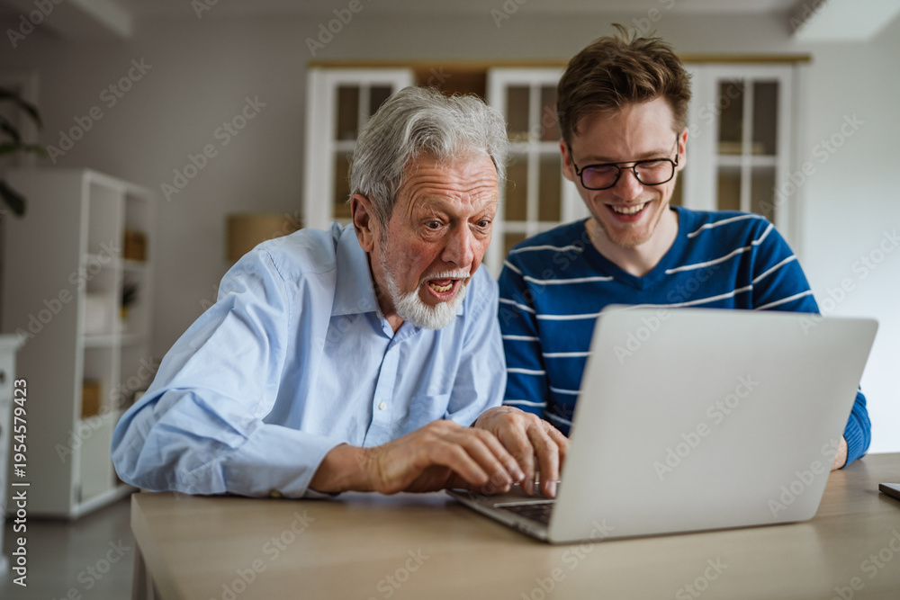 Fototapeta premium Senior man receiving technology advice from grandson