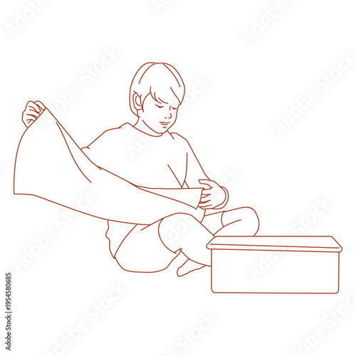 boy folding clothes while sitting on the floor.eps