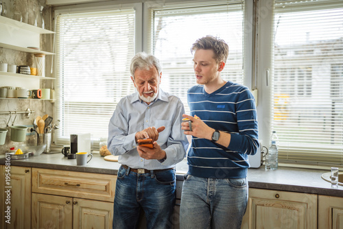 Photos Family members discussing technology and generational differences in home kitche