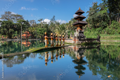 Cuadro en lienzo Traditional Balinese dancers and a multi-tiered temple shrine reflecting in the