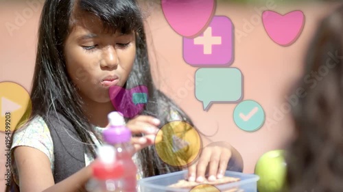First bite starting, kid chewing and packing sandwich into clear box to store while icons rising