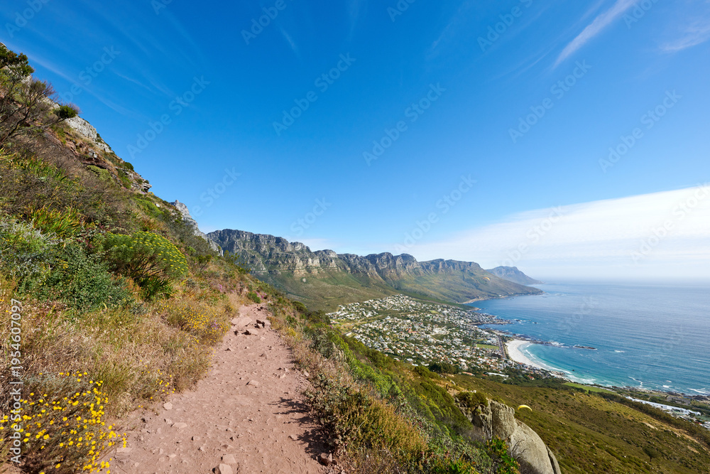 Fototapeta premium Hiking trail, blue sky and mountains with environment, path in nature and destination with space. Empty, outdoor and hills with summer holiday, tropical island and location for tourism or plants