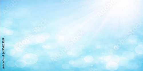 An abstract blue bokeh background blends into a bright summer sky filled with beautiful white fluffy clouds and sunny light for a clear heaven atmosphere