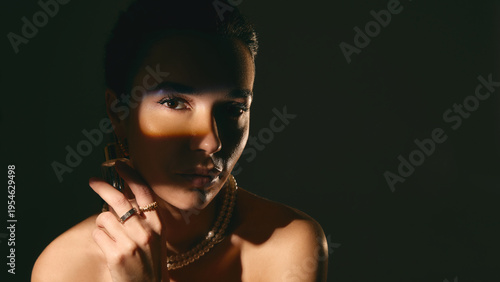 Woman with serum bottle and light stripe across eyes in dark moody lighting. Concept of cosmetic branding, skincare promotion, premium product marketing and beauty advertising.