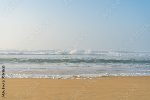 Belles vagues avec écume sur la plage de Vieux Boucau sous un soleil voilé