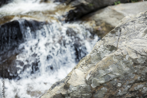 Canvastavla Close up view of peaceful water stream and waterfall flowing over textured rock