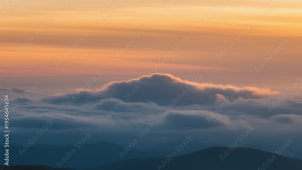 Fototapeta premium Sunset over mountain peaks with layered clouds and warm sky hues