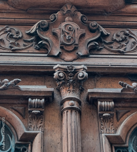 Ornamental carved facade detail above pilaster capital on historic stone building in Montpellier