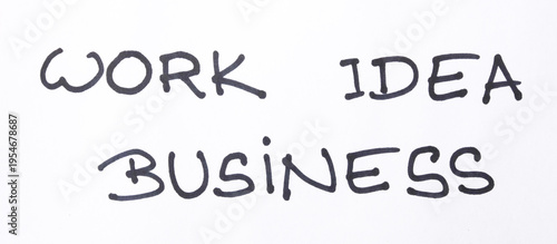 A minimalist, conceptual close-up of the words 'WORK IDEA BUSINESS' handwritten in bold black ink on a clean white surface, symbolizing the essential lifecycle of professional growth 