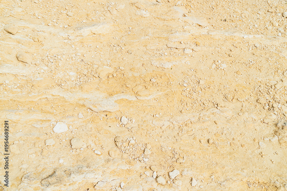 Obraz premium Dry ground covered with light colored stones and small rocks at a construction site in midday sun