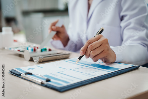 Foto Doctor in white coat fills medical form on clipboard at clinic desk with pills and blister pack in background, close-up hands writing prescription, healthcare documentation concept