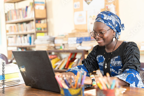 Smiling African student at her laptop in university library