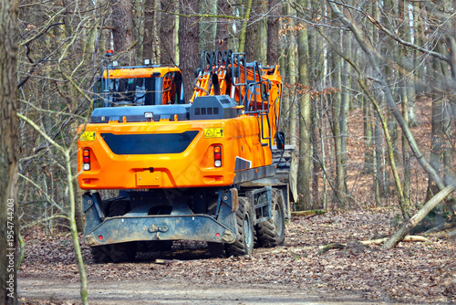 Billede på lærred Orange Wheeled Excavator in a Forest
