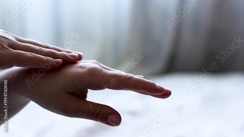 A woman moisturizes her skin with cream