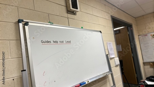 Inspirational Message on Whiteboard in Classroom Setting Encouraging Guidance Over Leading in Education Environment