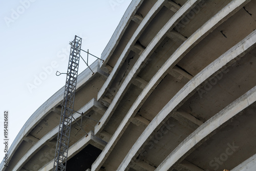 Construction of a modern multi-story building, with an external metal fire escape on the side. Construction of an apartment building using concrete and monolithic slabs in a resort area of ​​Romania.