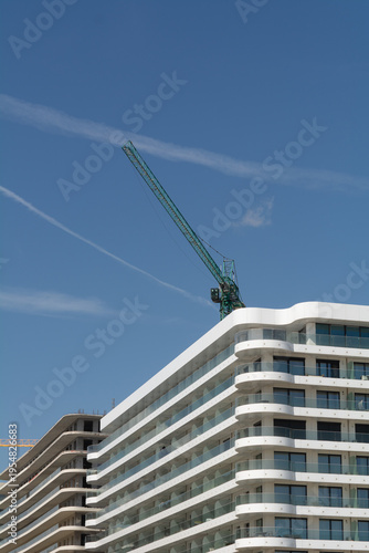 Construction of an apartment building in a resort area of ​​Romania. Glazed balconies, windows, construction completion stage, developer company,construction crane