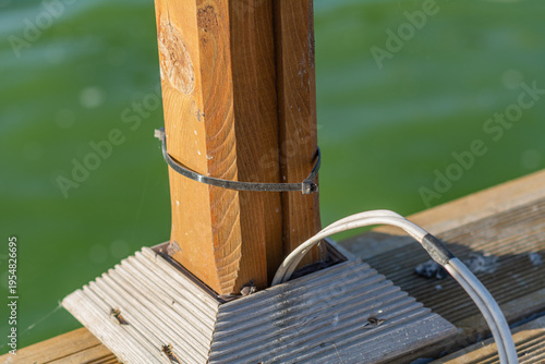 Electrical wiring for lighting a fishing pier, a wooden boat dock on a lake in Romania. wooden pier electricity