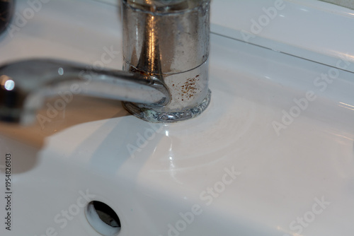 Rust and corrosion on a sink faucet. Water quality. Faucet failure due to alkaline water in the apartment. Selective focus, shallow depth of field.