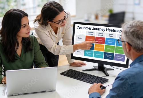 Businesswoman explaining customer journey heatmap to colleagues in modern office