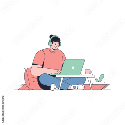 Person working on laptop with headphones, sitting on floor with beanbag chair