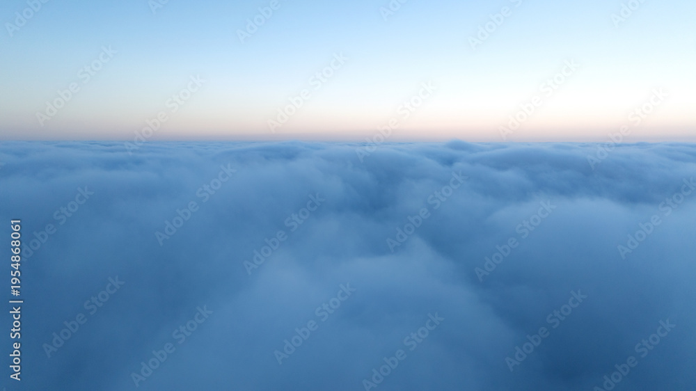 Obraz premium Drone shot sunset over clouds high altitude landscape. Sun light shining over white fluffy clouds. Scenic natural phenomenon travel photography atmospheric beauty background.
